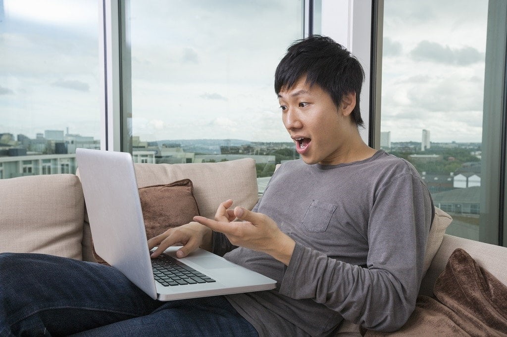 homme surpris devant son notebook
