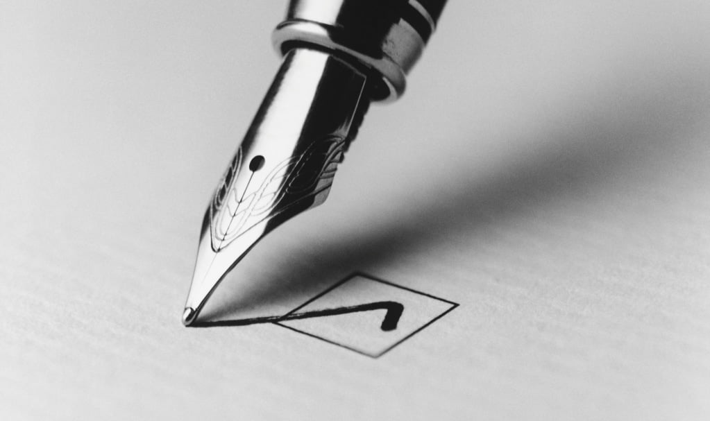 stylo plume cochant une case sur une feuille papier